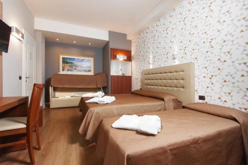 a hotel room with two beds and a table at Bed & Breakfast Armonie Romane in Rome