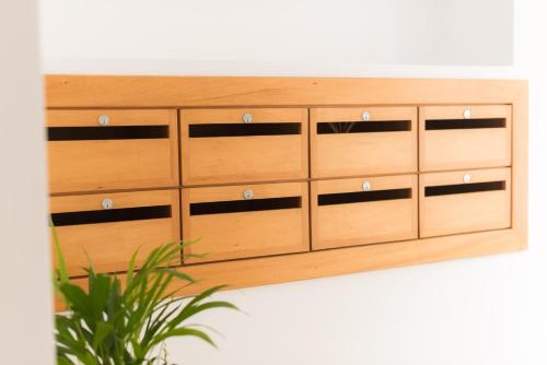 a wooden cabinet with four drawers and a plant at Apartamentos Praça Amarela by Heart of Funchal in Funchal