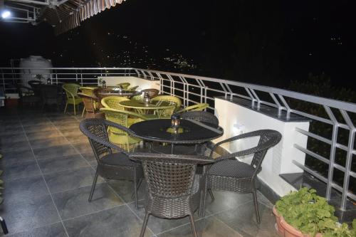 a row of tables and chairs on a balcony at night at Cloud 7 in Nainital