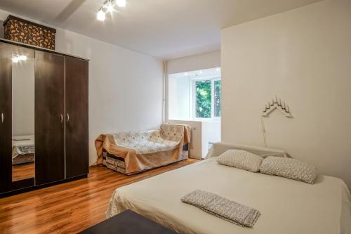 1 dormitorio con 1 cama, vestidor y silla en Residence 30, en Bucarest
