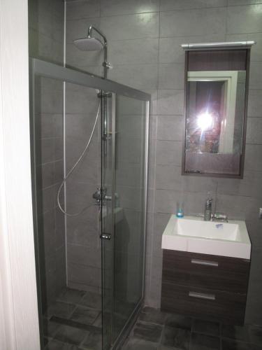 a bathroom with a shower and a sink and a mirror at Great view apartment near Piazza Batumi in Batumi