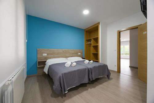 a bedroom with a large bed with a blue wall at A Chousa in Arzúa