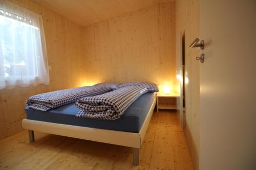 a bed in a small room with a window at Chalet Nr. 50 in Flühli