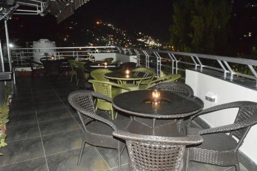 a row of tables and chairs on a balcony at night at Cloud 7 in Nainital