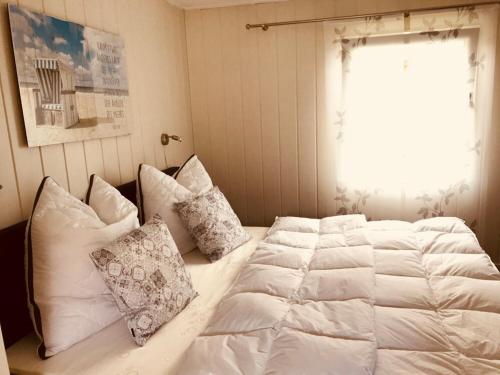 a bedroom with a white bed with pillows and a window at Ferienwohnung Thiemig in Neuhaus