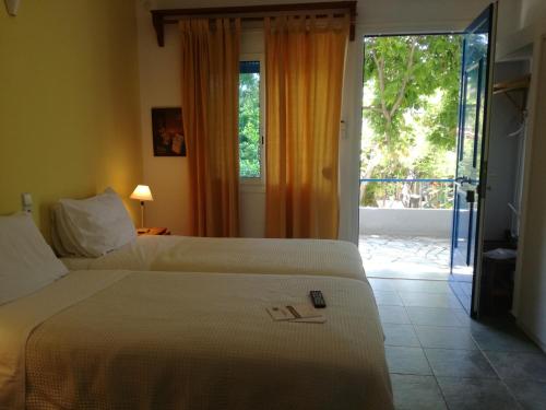 a hotel room with a bed and a sliding glass door at Ikion Studios in Steni Vala Alonissos