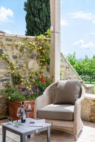 a wicker chair and a table on a patio at Borgo Argiano in Castelnuovo Berardenga
