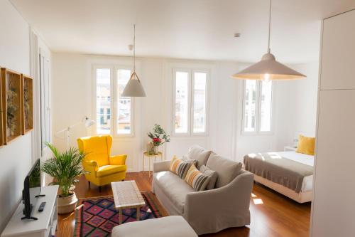 uma sala de estar com um sofá e uma cama em Apartamentos Praça Amarela by Heart of Funchal no Funchal