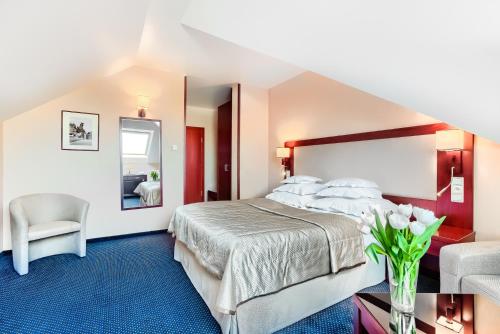 a hotel room with a bed and a chair at Hotel Atrium in Szczecin