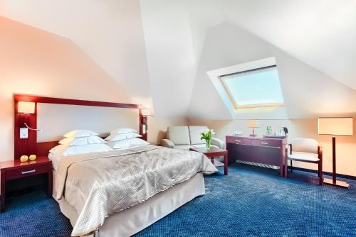 een slaapkamer met een bed, een bureau en een raam bij Hotel Atrium in Szczecin