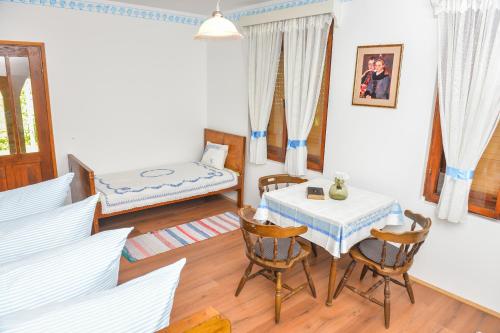 een woonkamer met een tafel en stoelen en een bed bij etno dom "zuza" in Kovačica