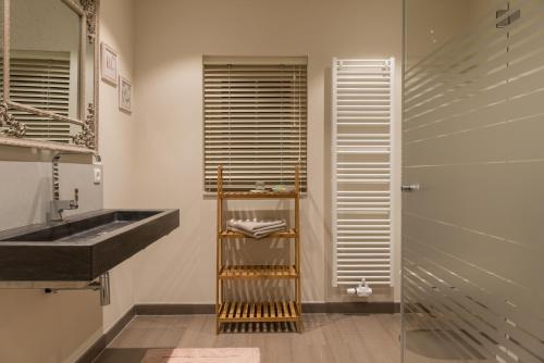 a bathroom with a black sink and a shower at B&B De Windheer in Sint-Martens-Lennik