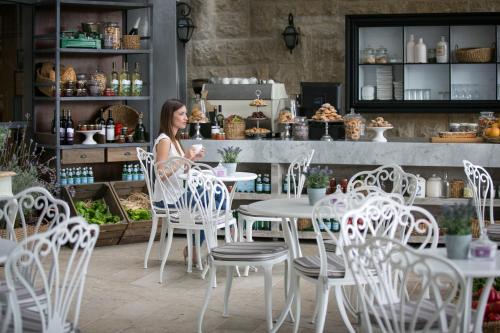 a woman sitting at a table in a cafe at Hotel Yehuda in Jerusalem