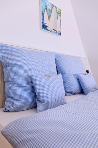 a bed with blue and white sheets and pillows at Logierhaus RheintorEins in Rees