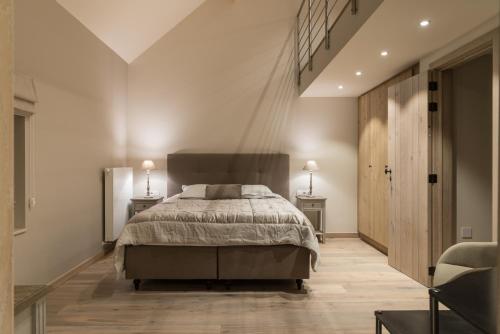a bedroom with a large bed and a staircase at B&B De Windheer in Sint-Martens-Lennik