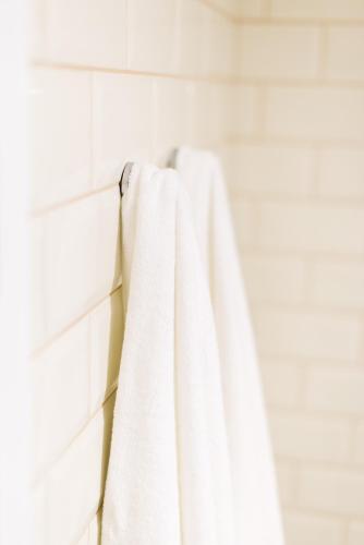 a white towel hanging on a rack in a bathroom at Apartamentos Praça Amarela by Heart of Funchal in Funchal