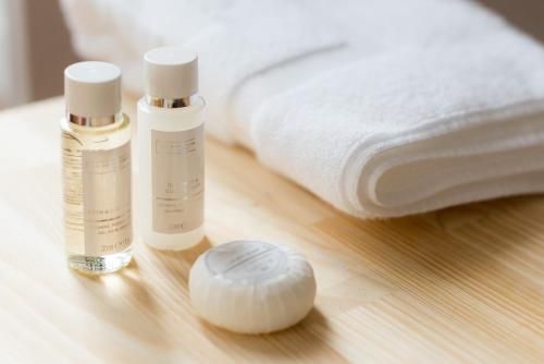 two bottles of moisturizing products on a table next to a bed at Apartamentos Praça Amarela by Heart of Funchal in Funchal