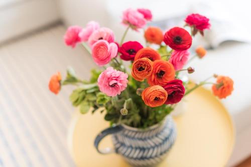 a vase filled with colorful flowers on a table at Apartamentos Praça Amarela by Heart of Funchal in Funchal