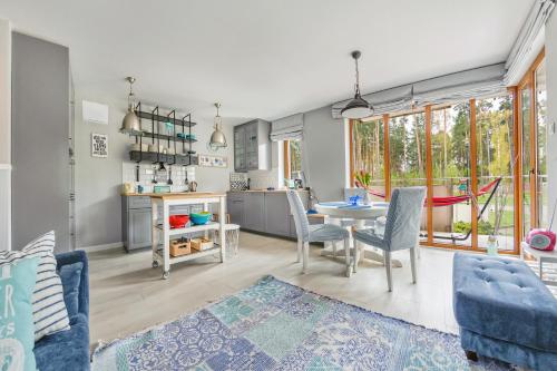 a living room with a table and chairs and a kitchen at Apartamenty Sun & Snow Baltic Park Stegna in Stegna
