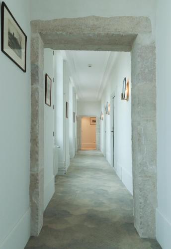 an empty hallway with white walls and a stone wall at Domaine de Saulon in Saulon-la-Rue
