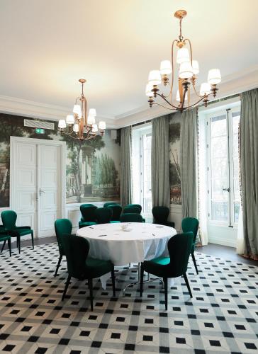 a dining room with a table and chairs and a chandelier at Domaine de Saulon in Saulon-la-Rue