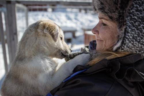 a woman holding a monkey in her arms at Ounasvaaran Lakituvat Chalets in Rovaniemi