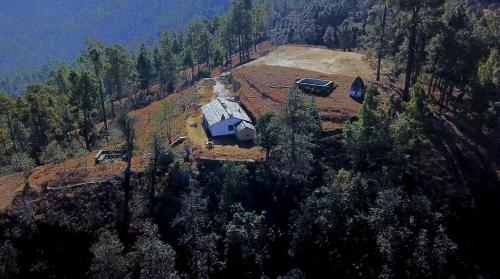 an aerial view of a house on top of a hill at Thikalna Himalayan Retreat in Almora