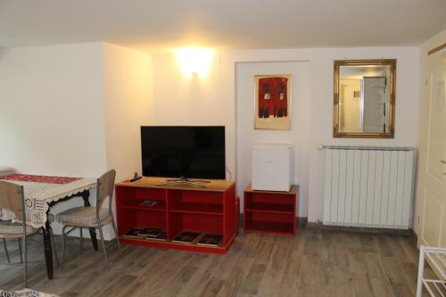 a living room with a tv and a table with a tableablish at Rooms Jurca in Postojna