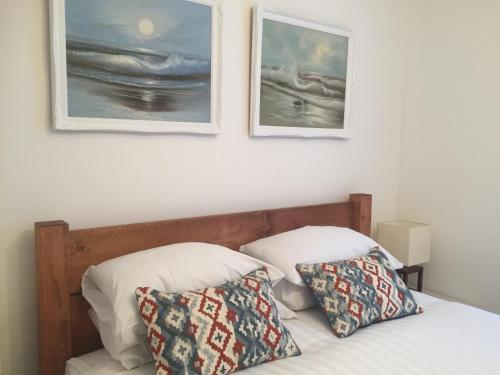 a bed with two pillows and two pictures on the wall at SeaQuest 5 in Newquay