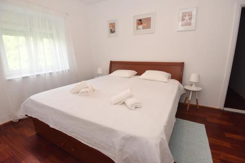 a bedroom with a white bed with towels on it at Sun and sea apartment in Zadar