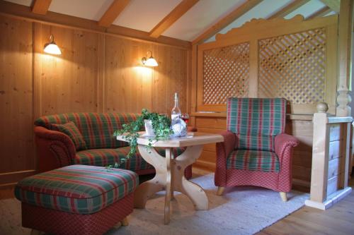 Zimmer mit 2 Stühlen, einem Tisch, einem Tisch und Stühlen in der Unterkunft Ferienapartment Haus Raith in Kreuth