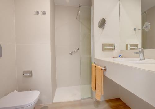 a bathroom with a shower and a toilet and a sink at SBH Maxorata Resort in Morro del Jable