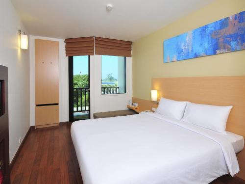 um quarto com uma grande cama branca e uma janela em Ibis Phuket Kata em Praia de Kata