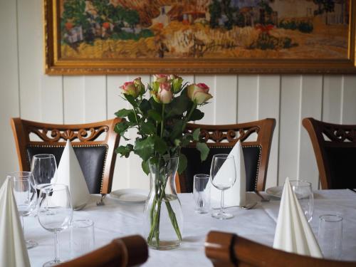 a table with a vase of flowers on it at Søstrene Storaas hotell in Bolkesjø