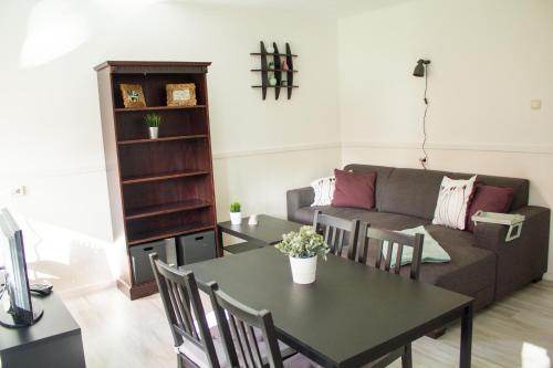 a living room with a couch and a table at Knusse Natuur Bungalow Hartje Veluwe in Otterlo