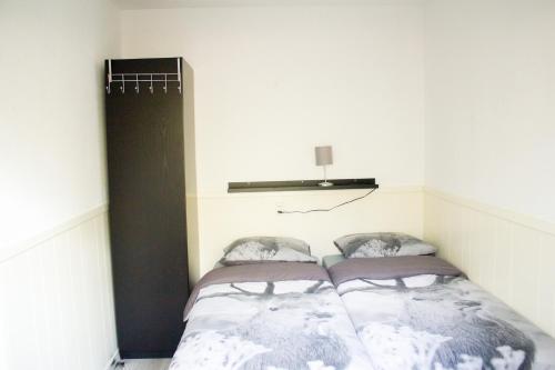 a small bedroom with two beds in it at Knusse Natuur Bungalow Hartje Veluwe in Otterlo