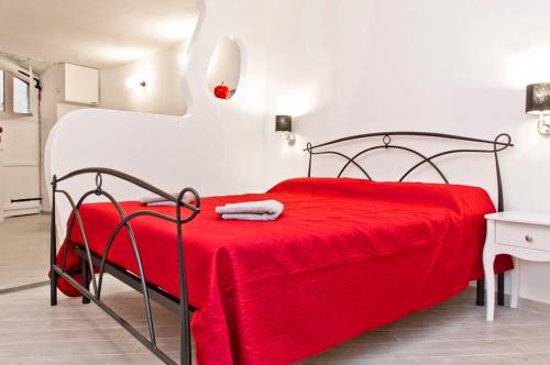 Cette chambre comprend un lit rouge avec une couverture rouge. dans l'établissement Petite Lamarmora, à Cagliari