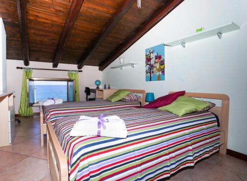 カーポ・ドルランドにあるSapore di Mareのベッドルーム1室(カラフルなストライプ毛布付きのベッド1台付)
