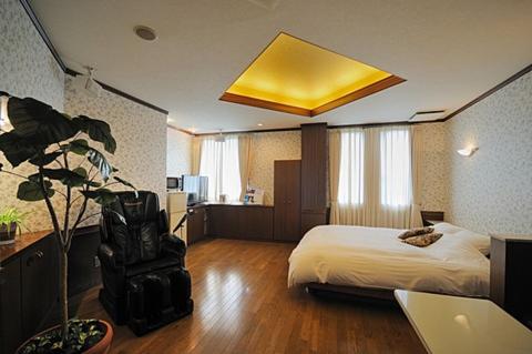 a hotel room with a bed and a yellow ceiling at Aube - 大人専用 in Konzōji