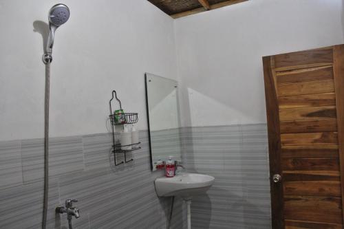 a bathroom with a sink and a mirror at Prasi Sunset Bungalows in Nusa Penida