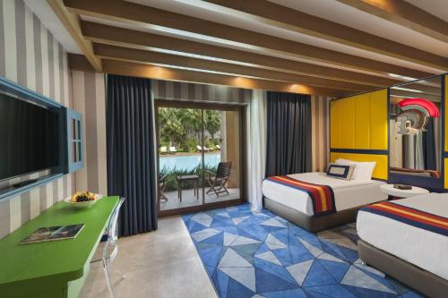a hotel room with a bedroom with a bed and a television at Rixos Premium Belek - The Land of Legends Access in Belek