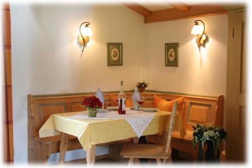 uma sala de jantar com uma mesa com flores em Ferienapartment Haus Raith em Kreuth