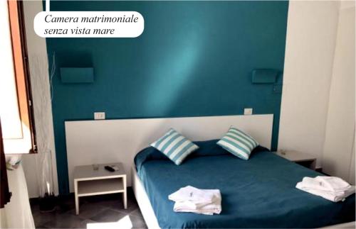 a bedroom with a blue and white bed with two pillows at Da Nino sul mare Filicudi in Filicudi