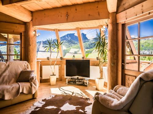a living room with a flat screen tv and windows at TatryTop Panorama Lux Spa in Kościelisko