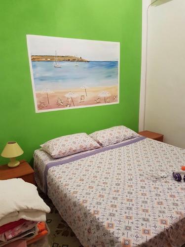 a bedroom with a bed and a painting of a beach at Lampedusa Vacanza in Lampedusa