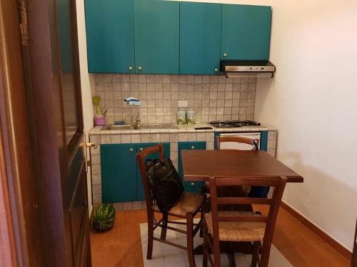 a kitchen with blue cabinets and a table and chairs at Lampedusa Vacanza in Lampedusa