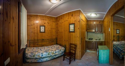 1 dormitorio con paredes de madera, 1 cama y lavamanos en Camping Nube D'Argento en Sorrento