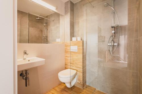 La salle de bains est pourvue de toilettes, d'un lavabo et d'une douche. dans l'établissement Łososiowa 3, à Jarosławiec