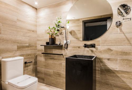 a bathroom with a toilet and a mirror at Hotel Pamplona Plaza in Pamplona