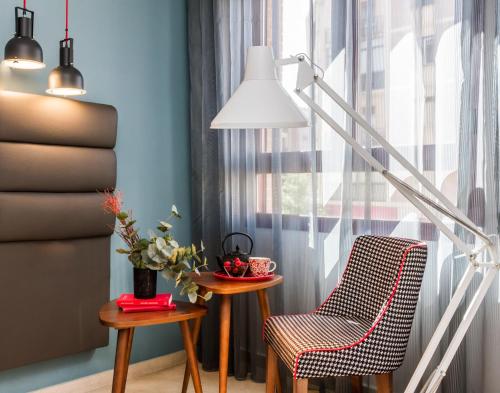 a room with a chair and a table and a lamp at Hotel Pamplona Plaza in Pamplona